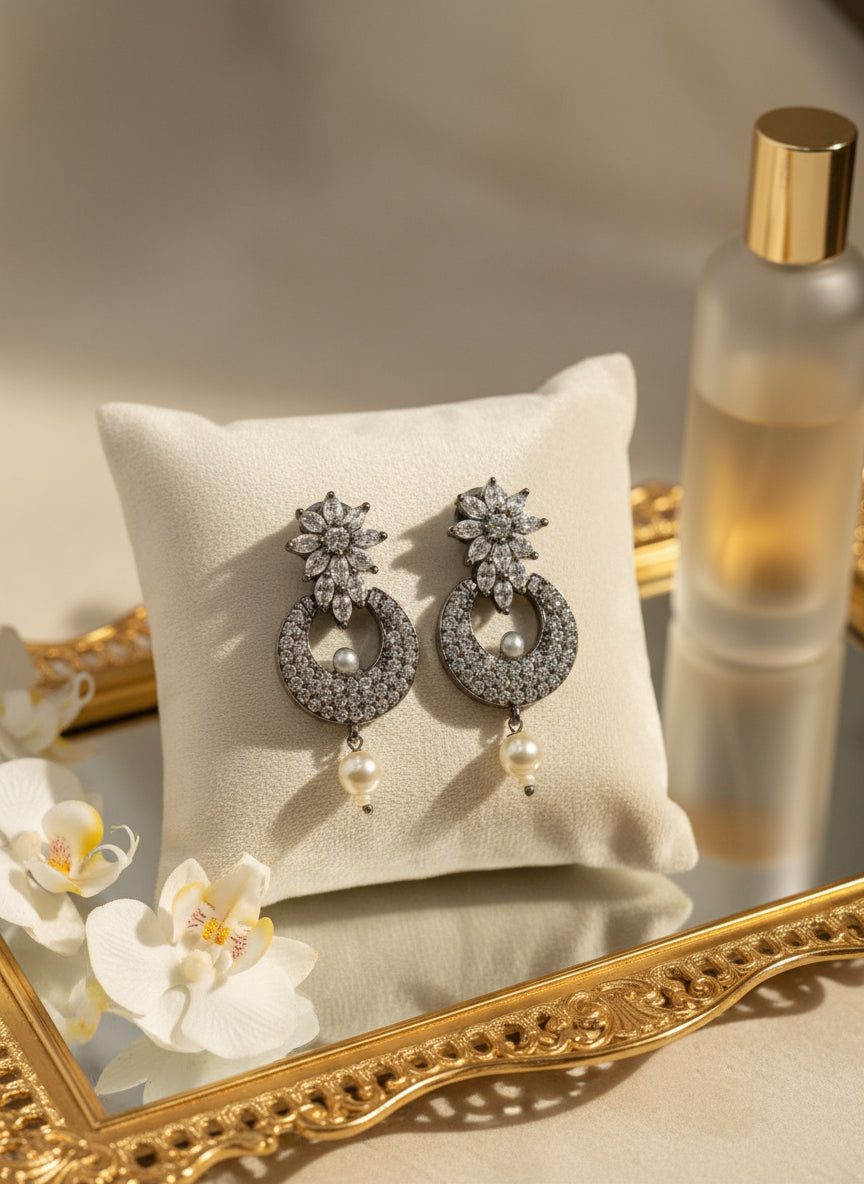 Elegant silver earrings with sparkling stone details and pearl drop, perfect for special occasions.