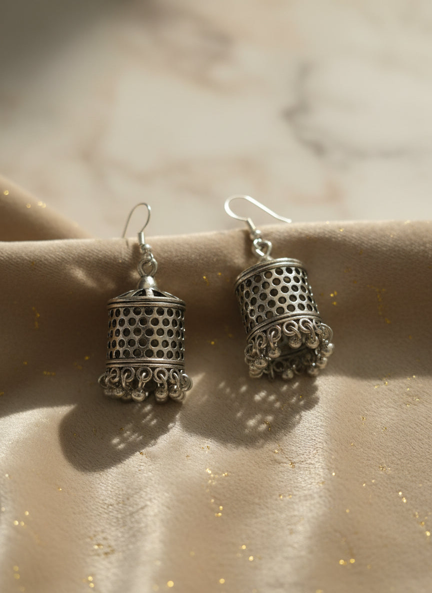 Silver filigree earrings with intricate cutouts and decorative beads, perfect for any occasion.