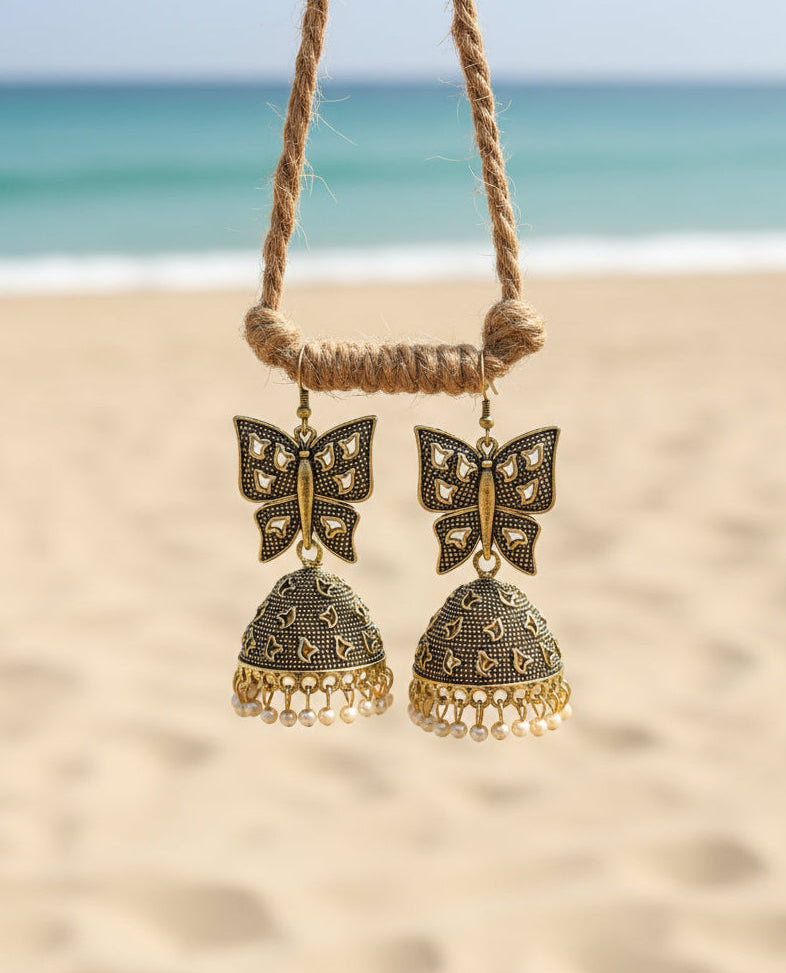 Gold butterfly jhumka earrings with pearl accents, perfect for boho beach style outfits.