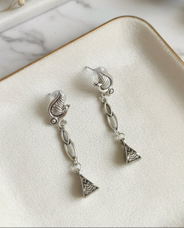 Silver drop earrings with decorative shell and triangular design, perfect for elegant occasions.