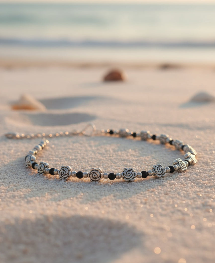 Handcrafted silver rose necklace with black beads, suitable for beachwear or casual outings.