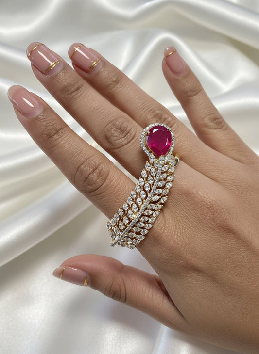 Elegant gold leaf design ring featuring a large pink gemstone and sparkling cubic zirconia accents.