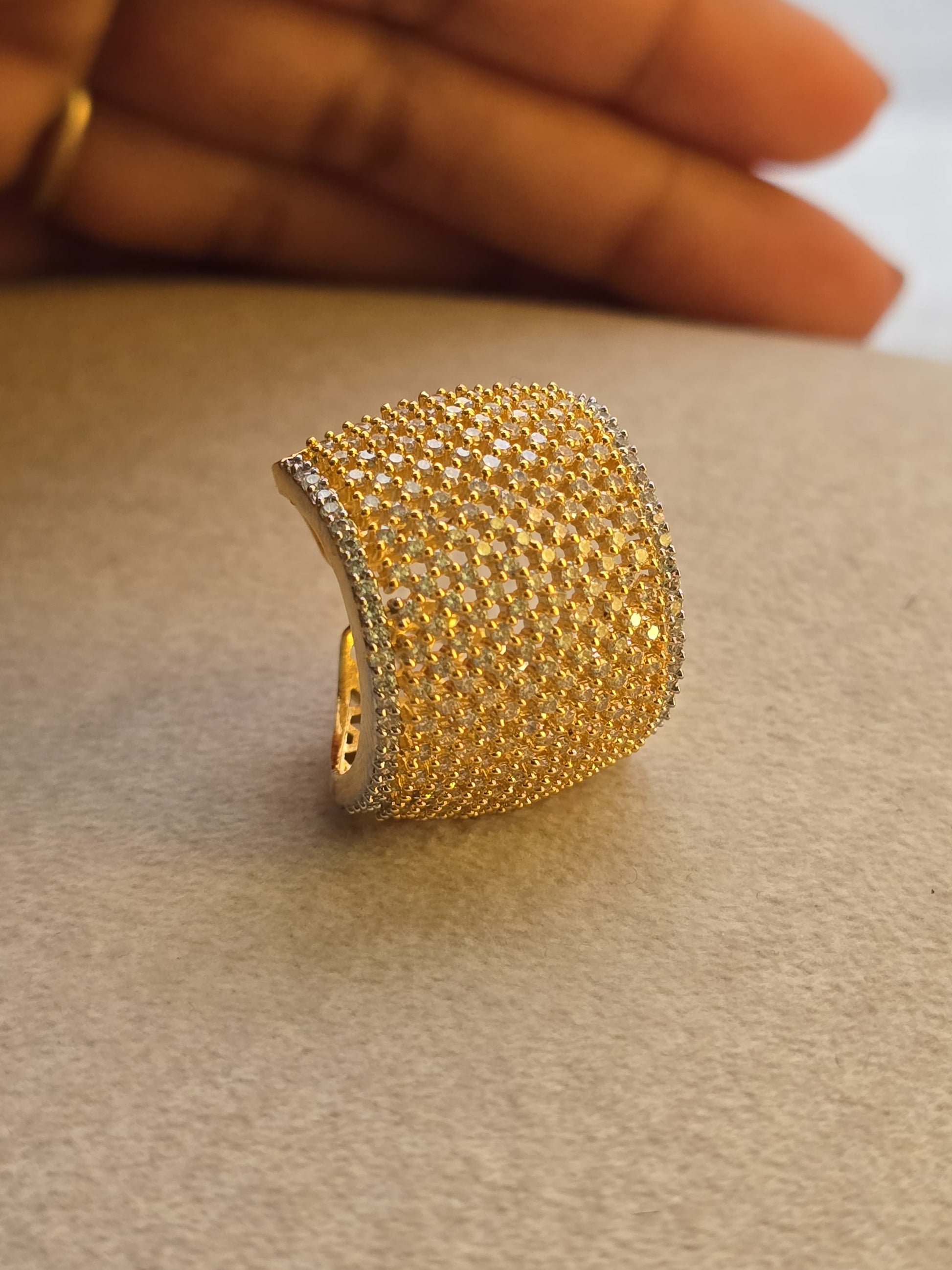 Elegant gold and silver ring adorned with shimmering rhinestones, featuring a curved design.