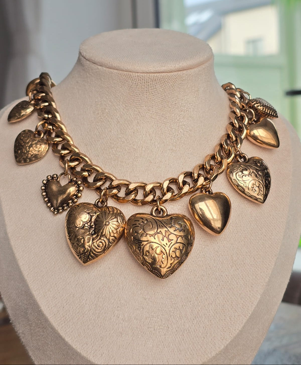 Vintage gold heart charm necklace with intricate detailing and chunky chain.