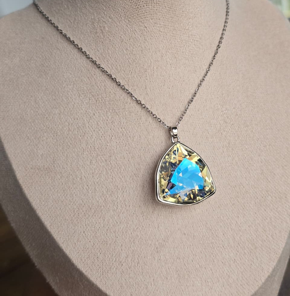 Elegant silver necklace featuring a large triangular blue and yellow crystal pendant.