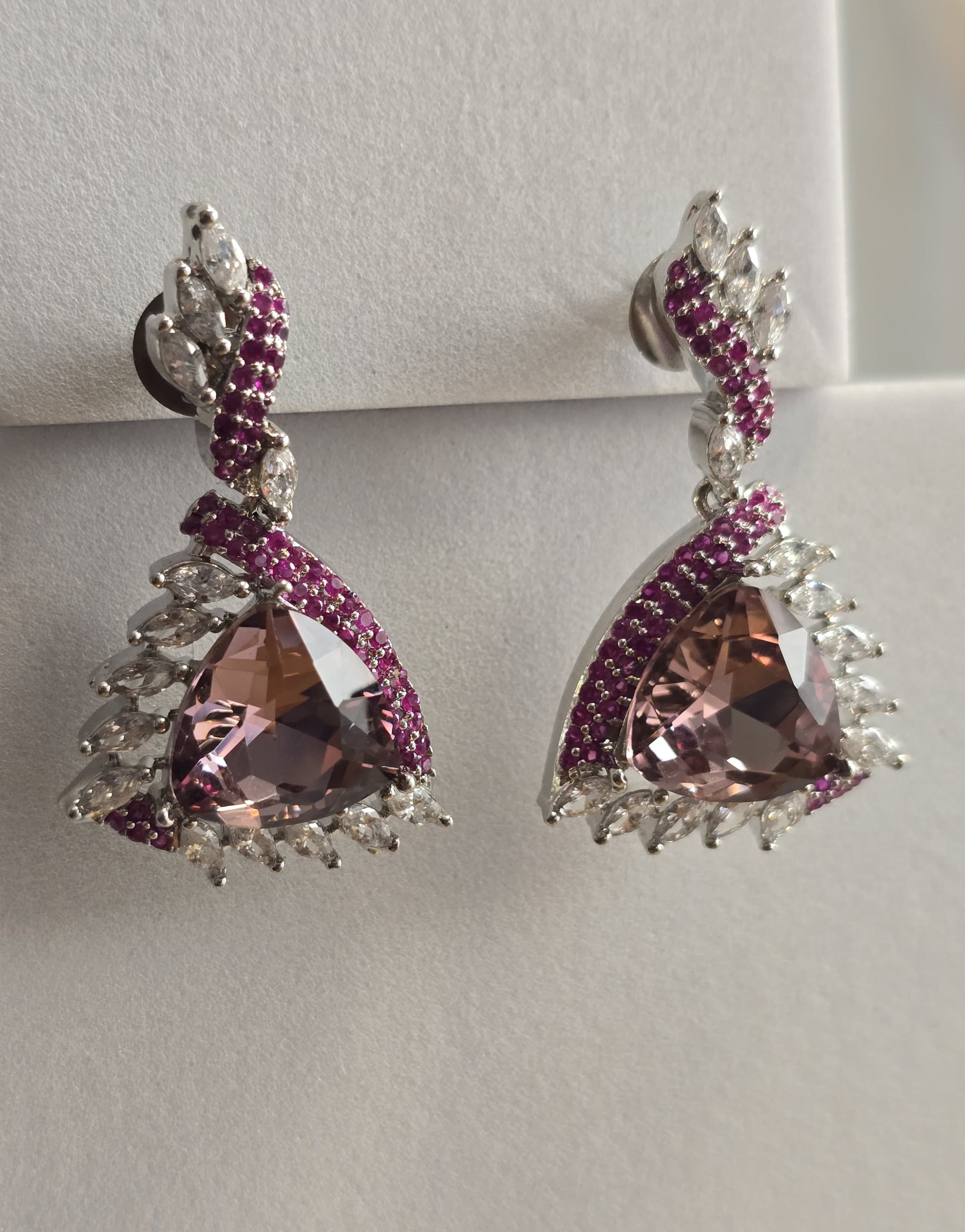 Elegant silver earrings featuring pink triangular stones and purple gemstone accents for a stunning look.