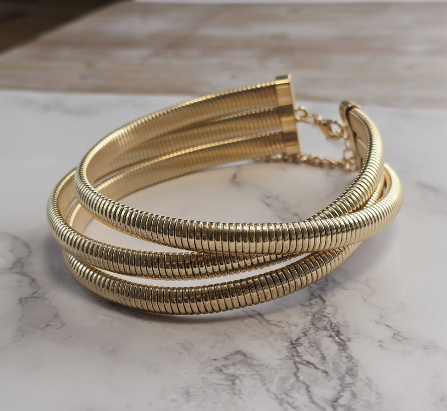 Gold multi-layer coil bracelet with sleek metallic finish, perfect for stylish accessories.