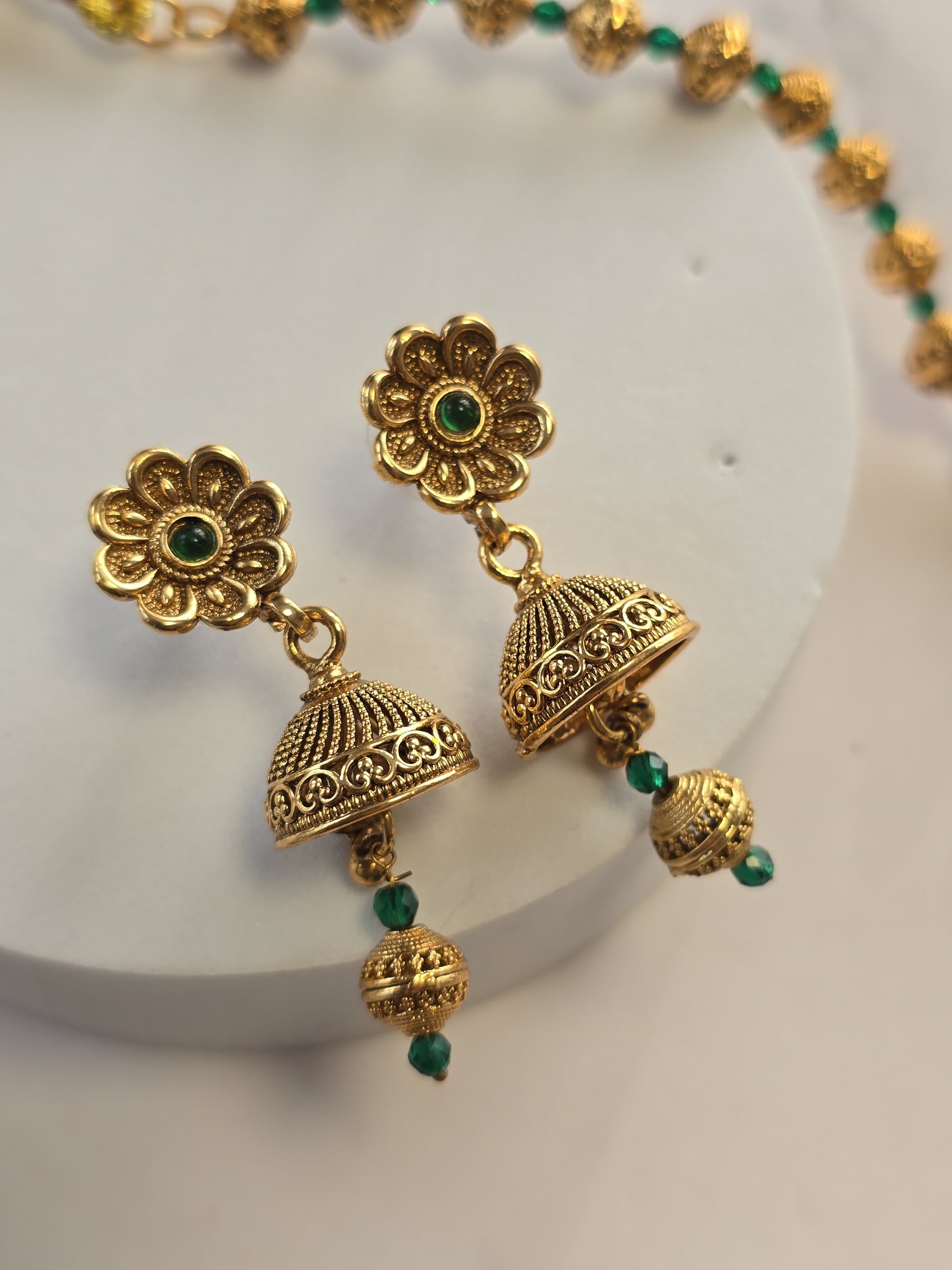 Gold-tone flower earrings with green accents, featuring intricate detailing and bell-shaped pendants.