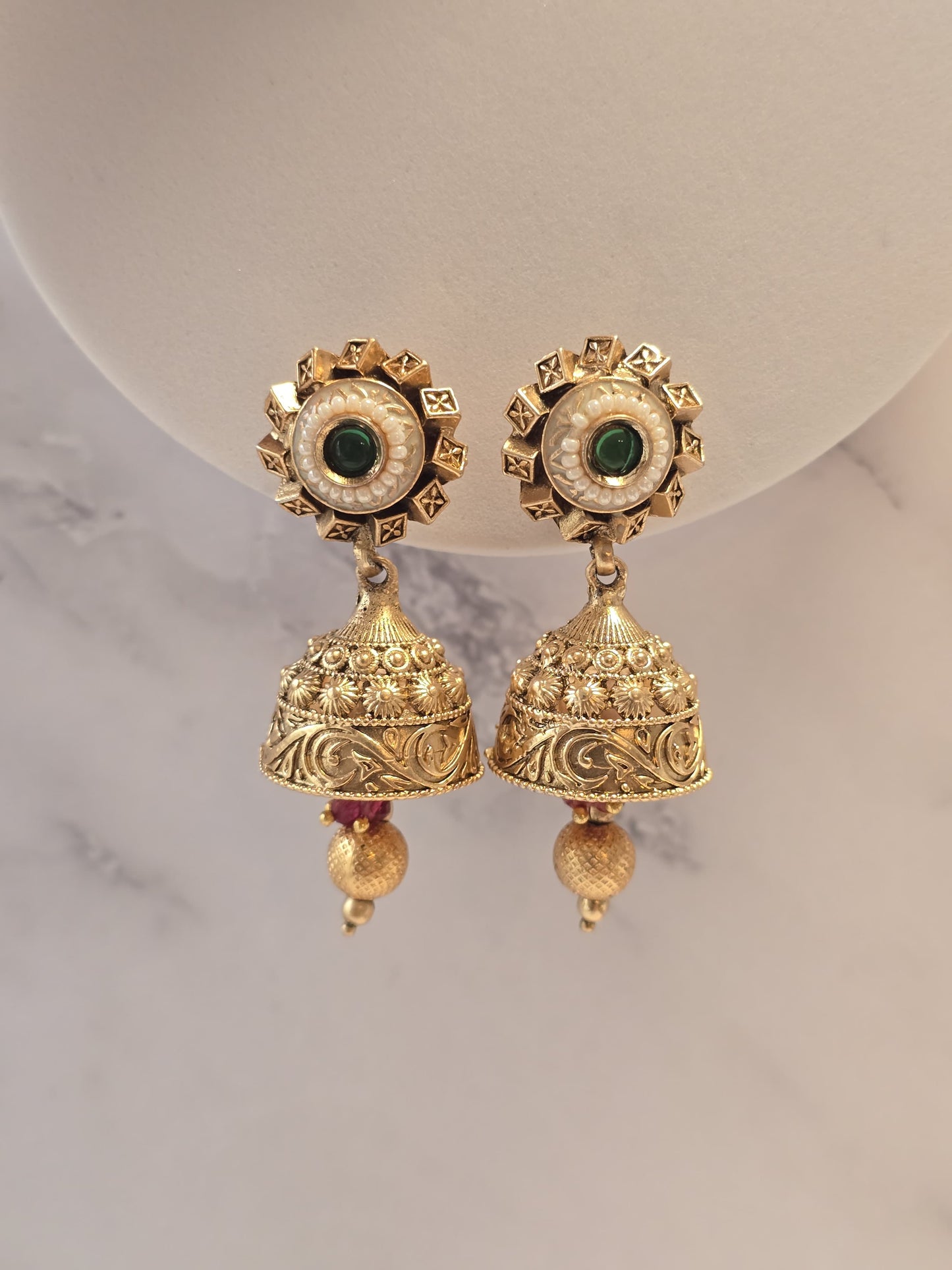 Gold-tone ethnic earrings with green stones and intricate bell design, perfect for festive occasions.