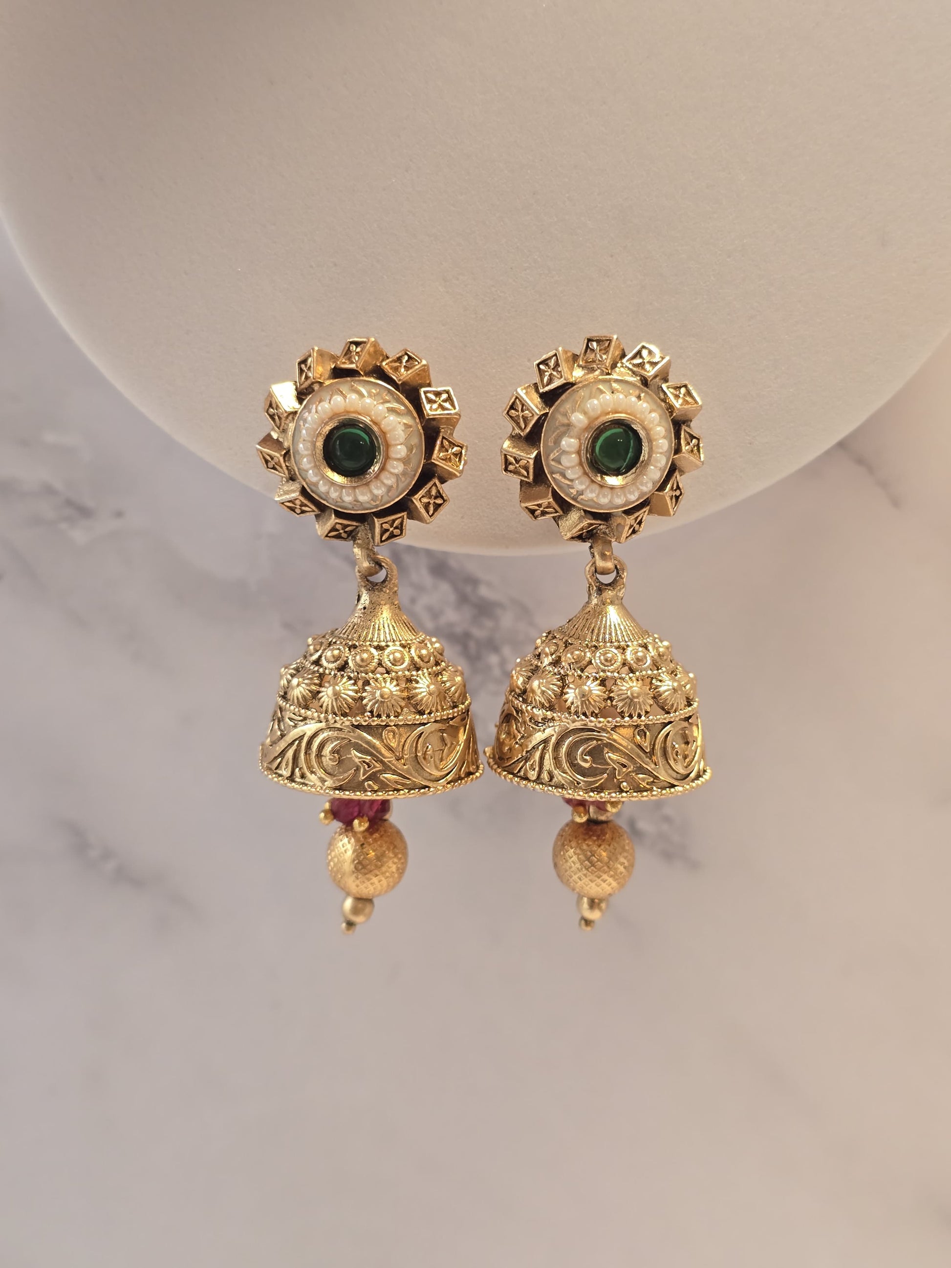 Gold-tone ethnic earrings with green stones and intricate bell design, perfect for festive occasions.