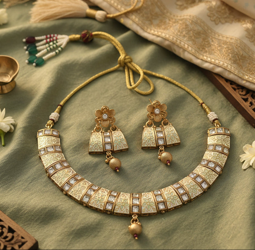 Traditional gold necklace and earrings set with green and white accents, featuring intricate floral designs.