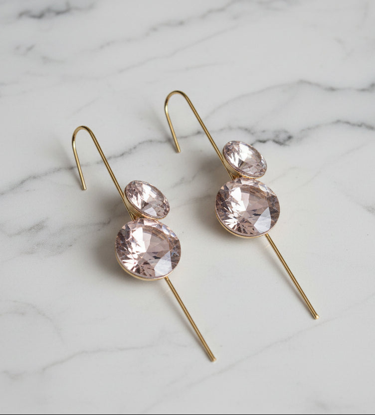 Gold drop earrings featuring two pink gemstones, elegantly designed for a chic look.