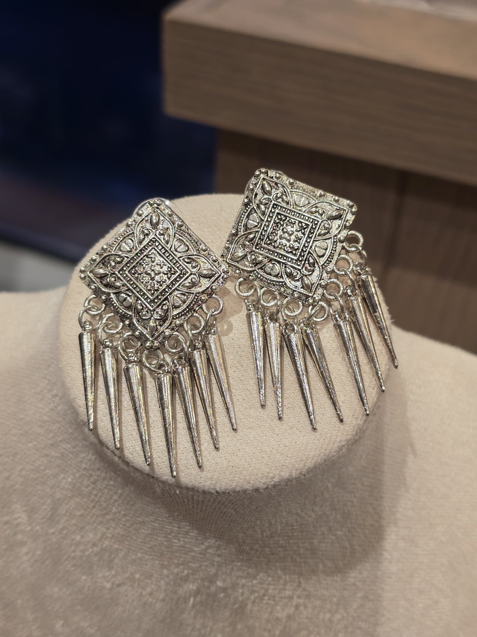 Elegant silver statement earrings with intricate design and pointed accents, perfect for formal occasions.