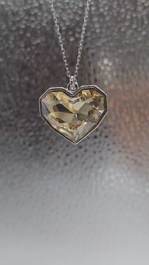Heart-shaped crystal pendant necklace in silver, featuring a faceted champagne-colored gemstone.