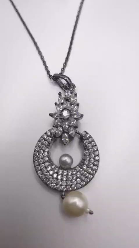 Elegant silver pendant necklace featuring rhinestones and a pearl drop detail.